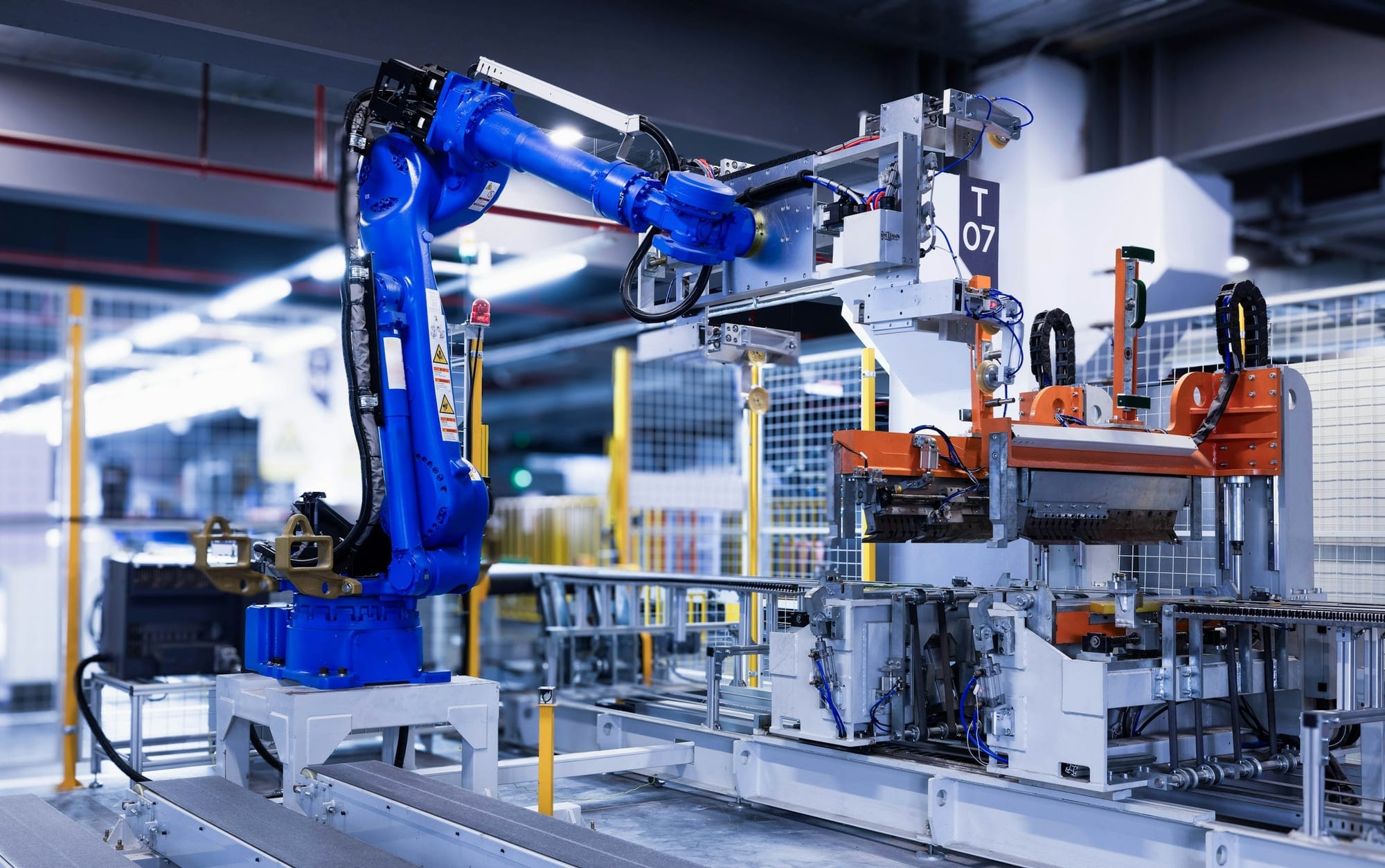 Üretim hücresinde çalışan endüstriyel robot kolu